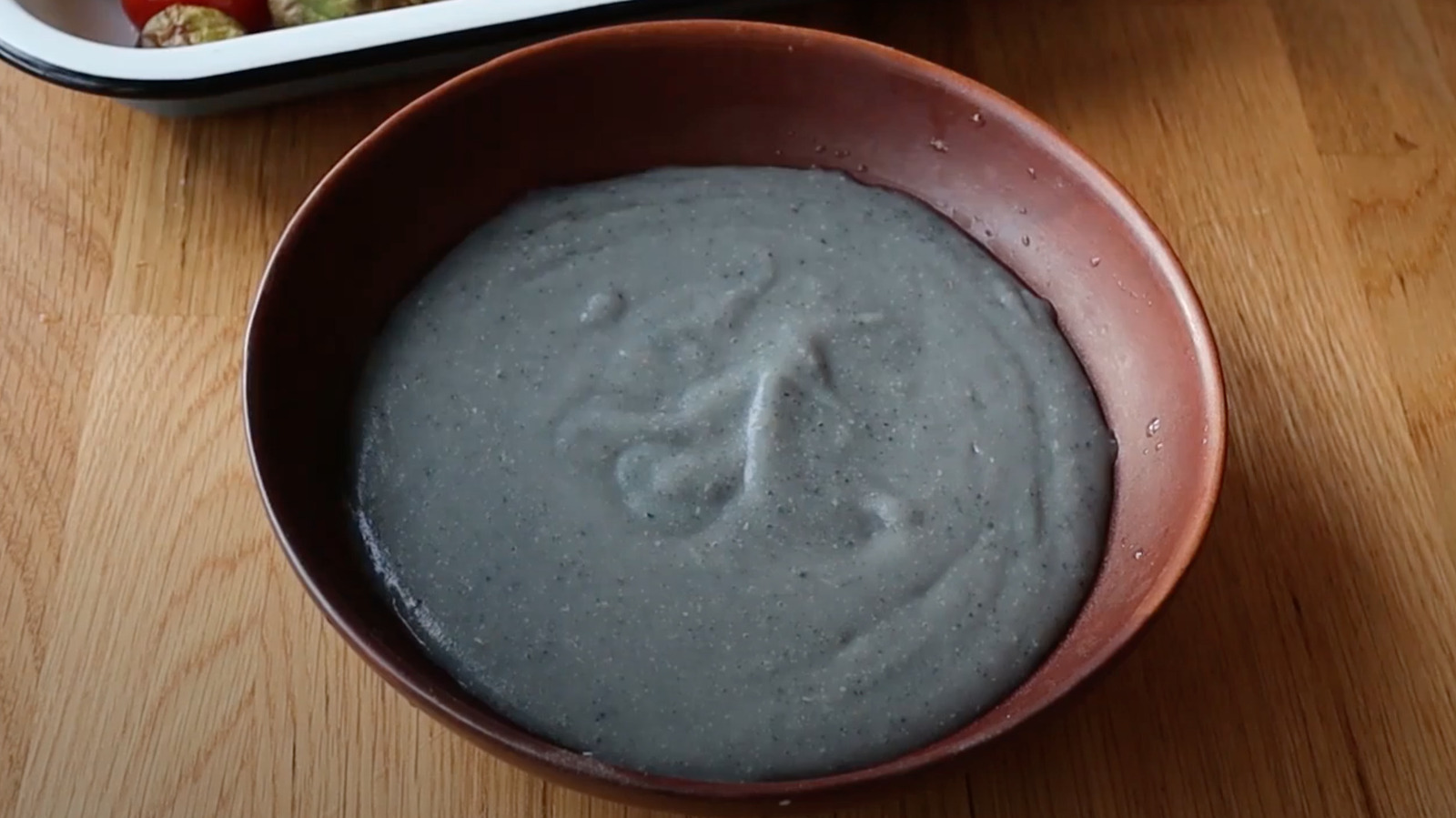 A bowl of cornmeal whisked with cold water until smooth and pourable on a kitchen counter