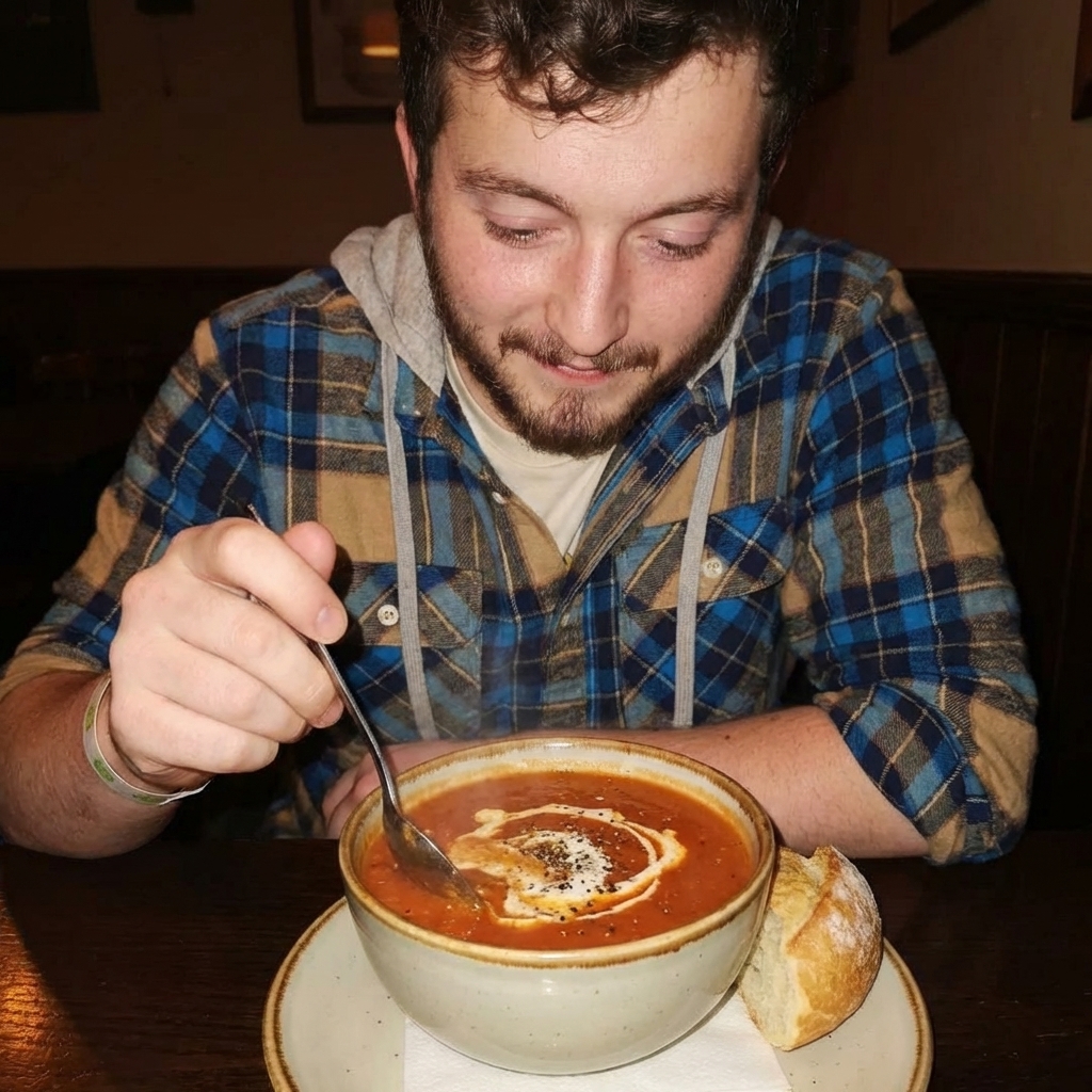 A bowl of cozy tomato soup with a swirl of cream and cracked pepper