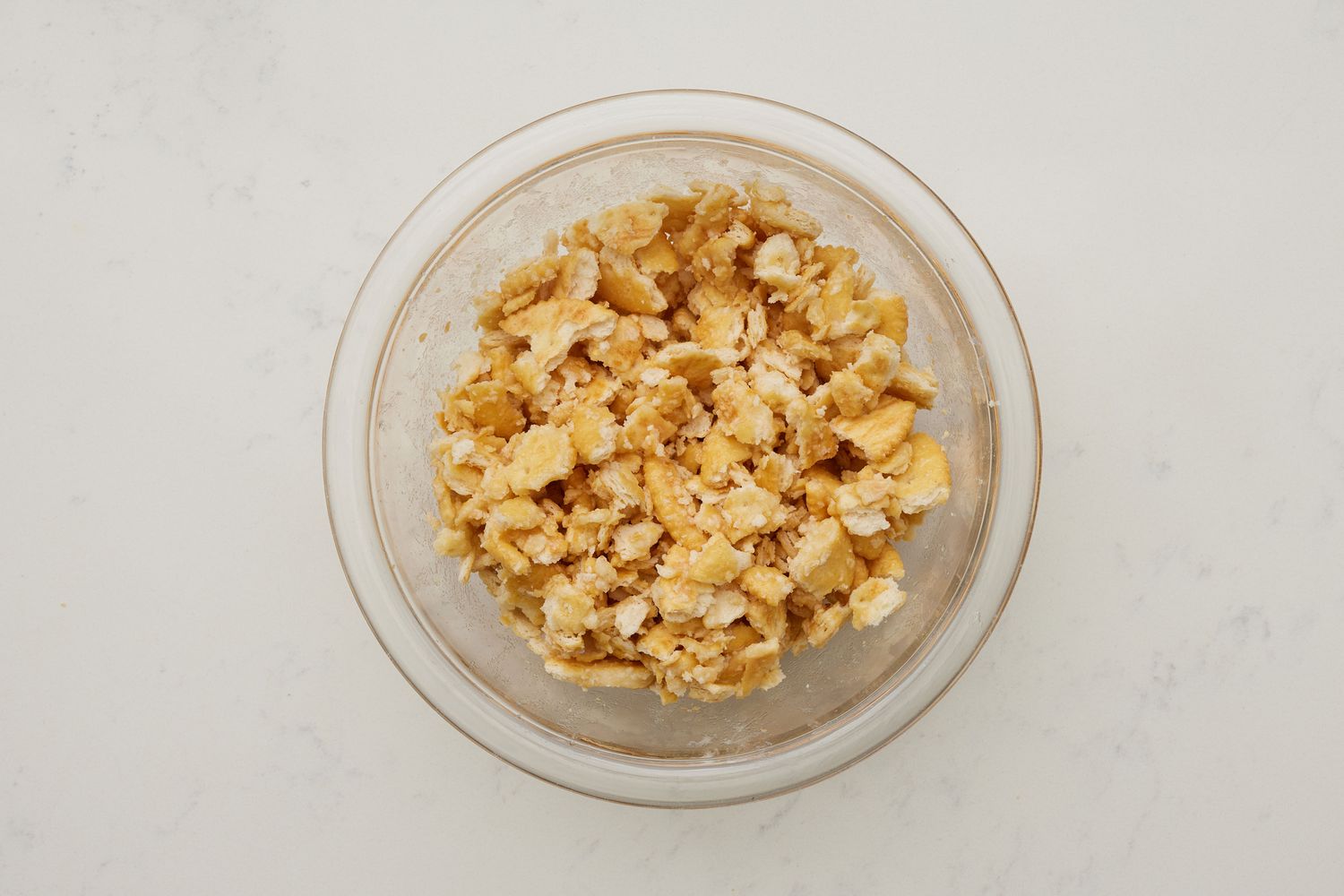 A bowl of crushed Ritz-style cracker crumbs mixed with melted butter and poppy seeds, ready to sprinkle over a casserole
