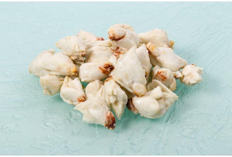 A bowl of lump crab meat on a kitchen counter with a fork nearby, showing large clean pieces ready to be folded into dip