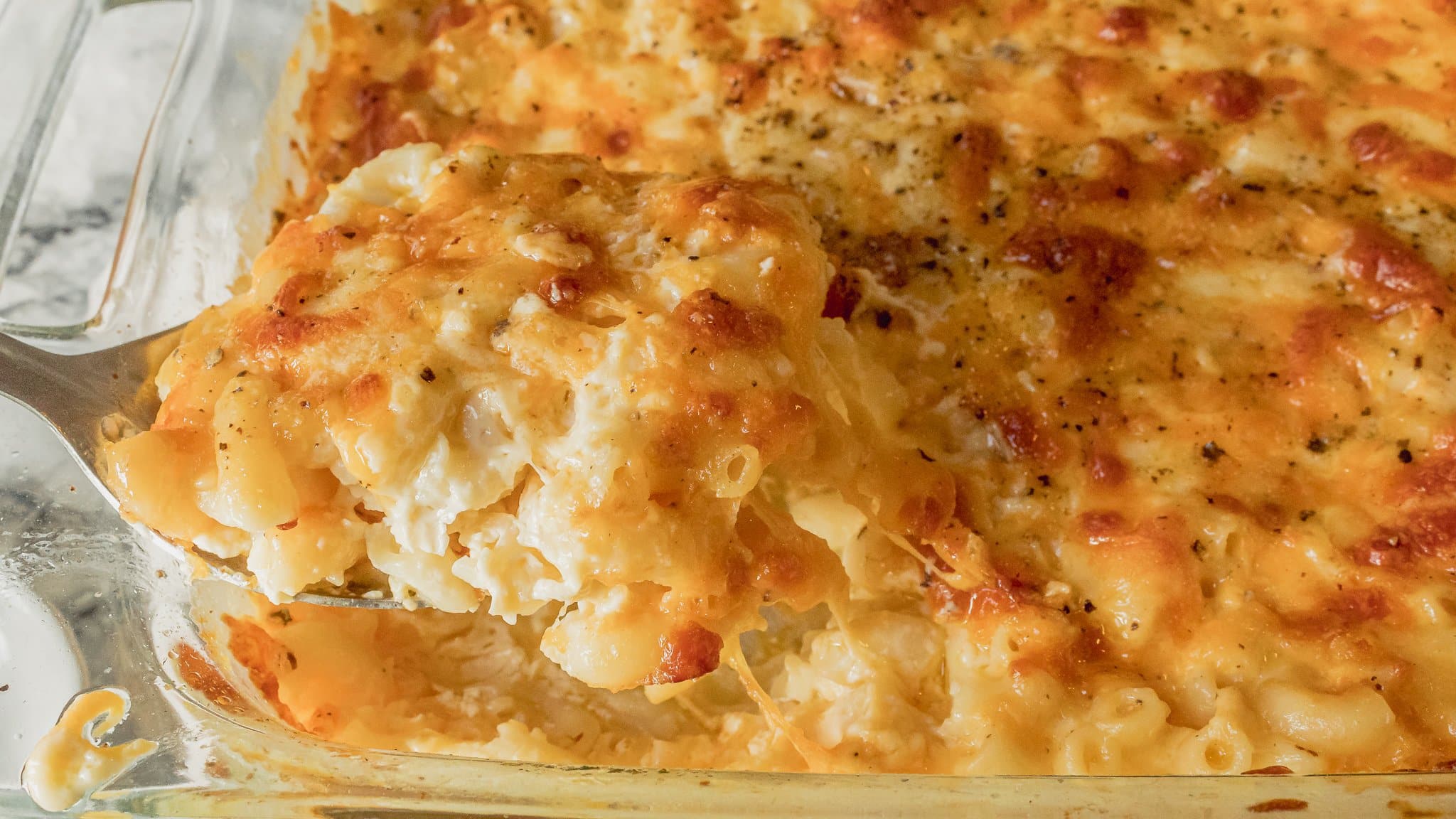 A bubbling casserole dish of Southern baked macaroni and cheese with a deep golden top and crispy edges on a warm kitchen counter