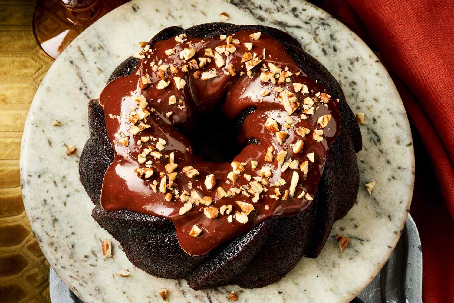 A bundt pan thoroughly greased and dusted with cocoa powder on a light stone countertop, ready for chocolate cake batter