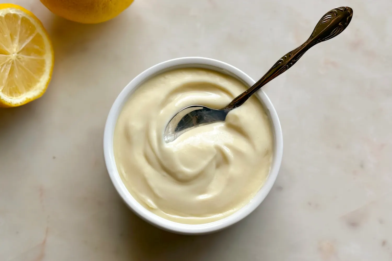 A can of sweetened condensed milk next to whole lemons and a lemon zester