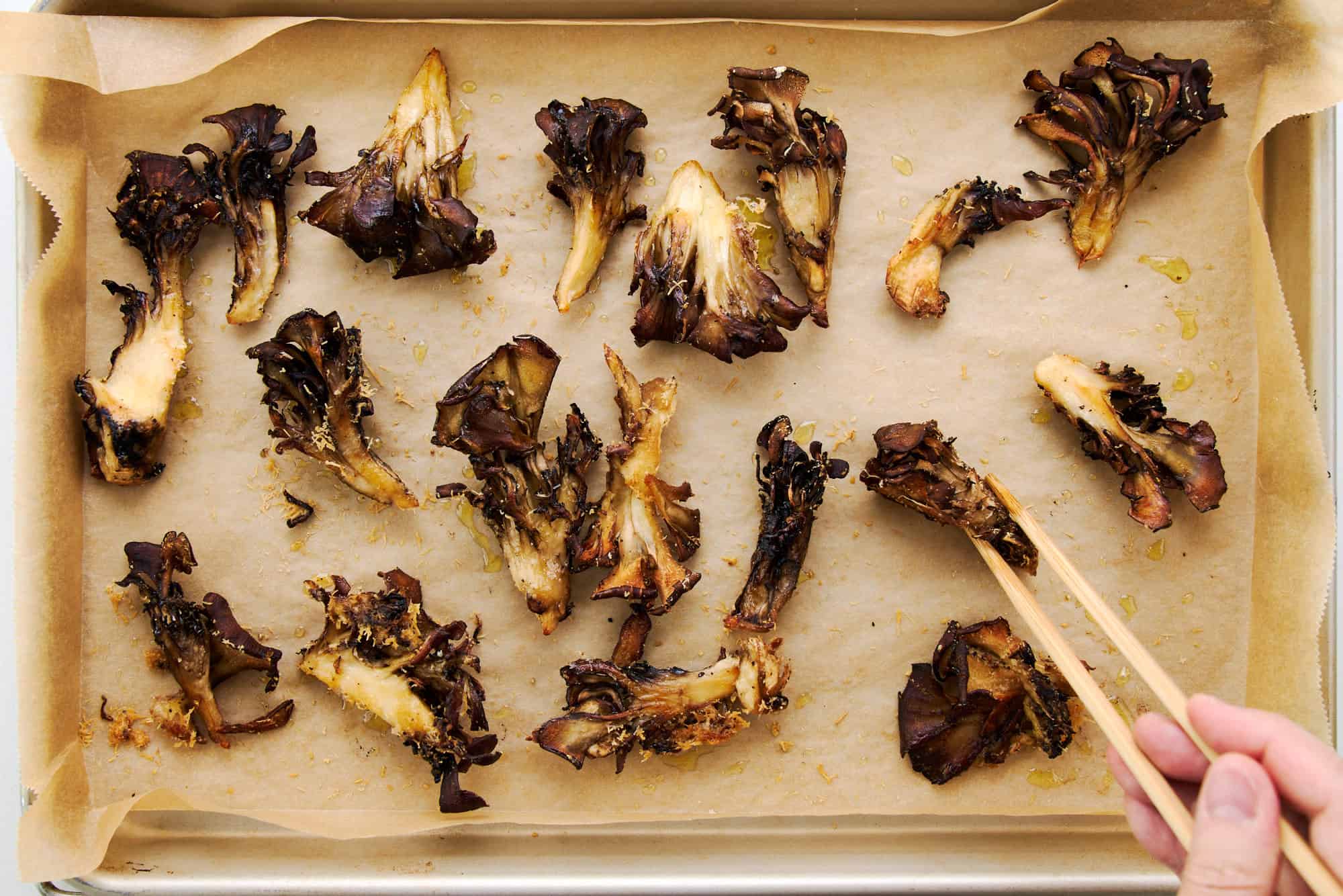 A cast iron skillet filled with golden-brown maitake mushrooms with crisp edges, lightly glossy from miso-butter, on a warm kitchen stove with soft natural light