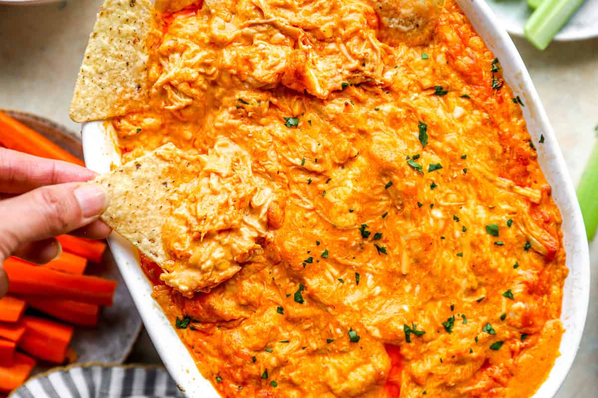 A ceramic baking dish of buffalo chicken dip on an oven rack with cheese melted and bubbling on top