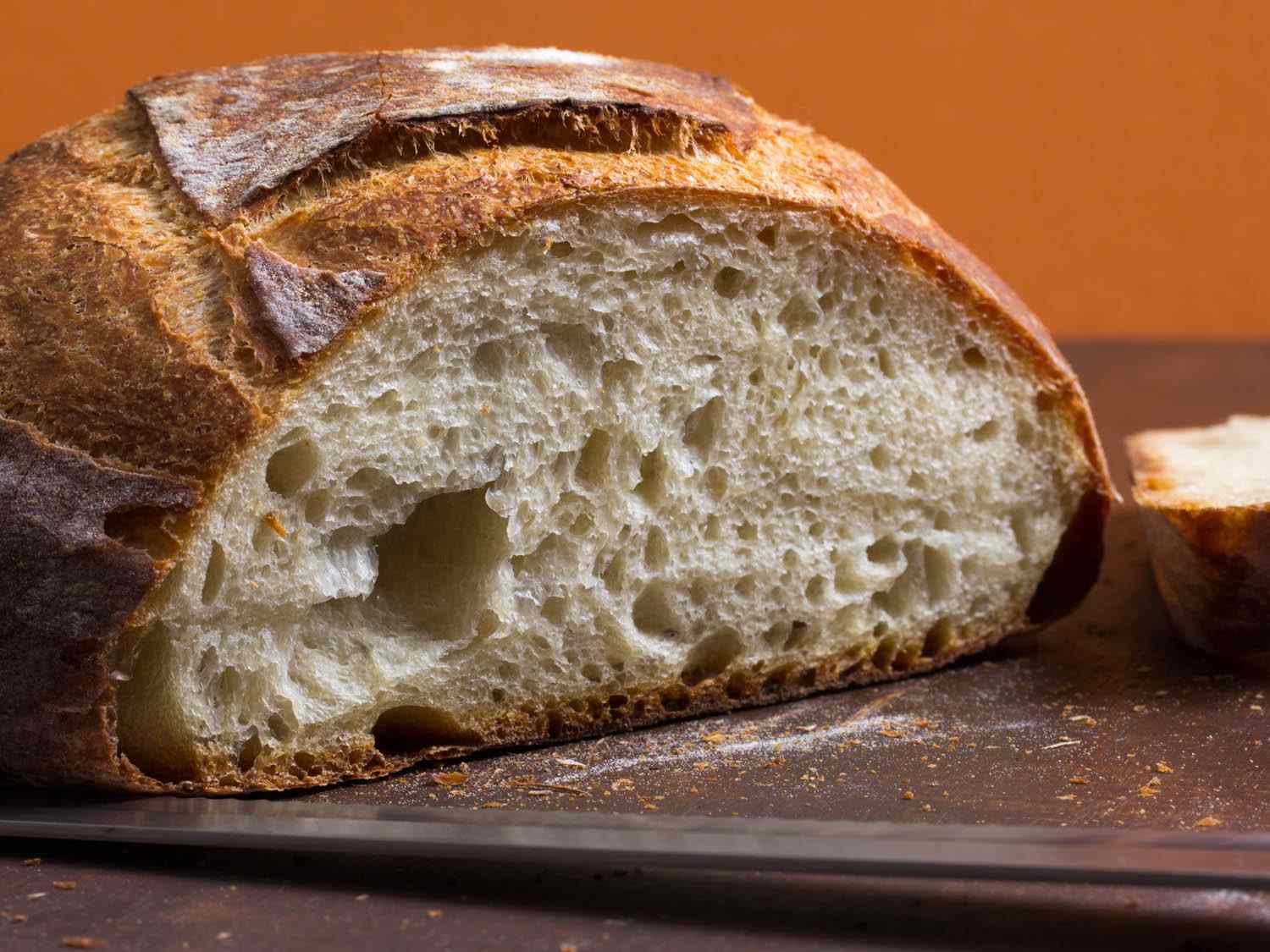 A close-up photo of a sliced crusty bread loaf showing an airy crumb