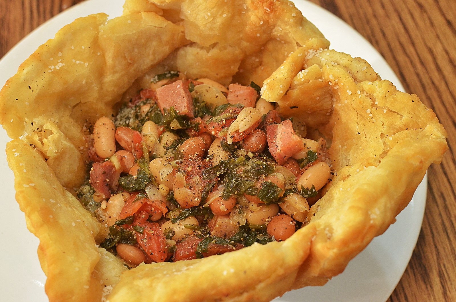 A covered bowl of rested fry bread dough on a clean kitchen counter with a towel draped over the top