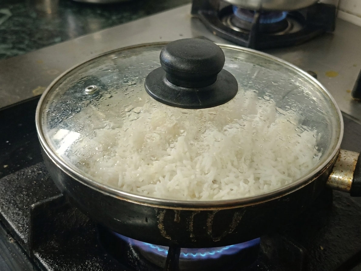 A covered saucepan cooking rice