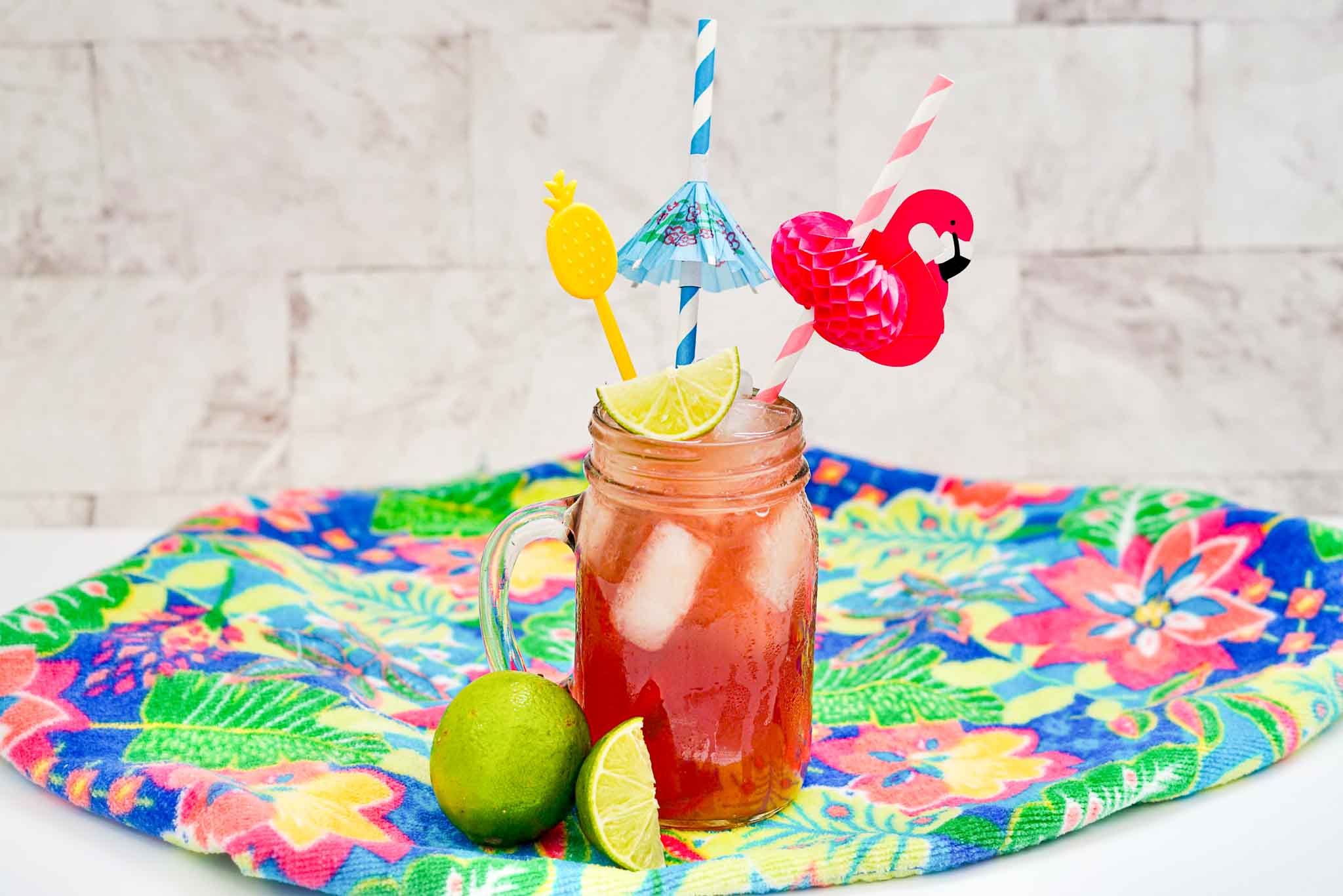 A frosty Malibu rum Bay Breeze slush in a clear glass with a sugared rim, lime wedge, and pineapple garnish on a bright kitchen counter
