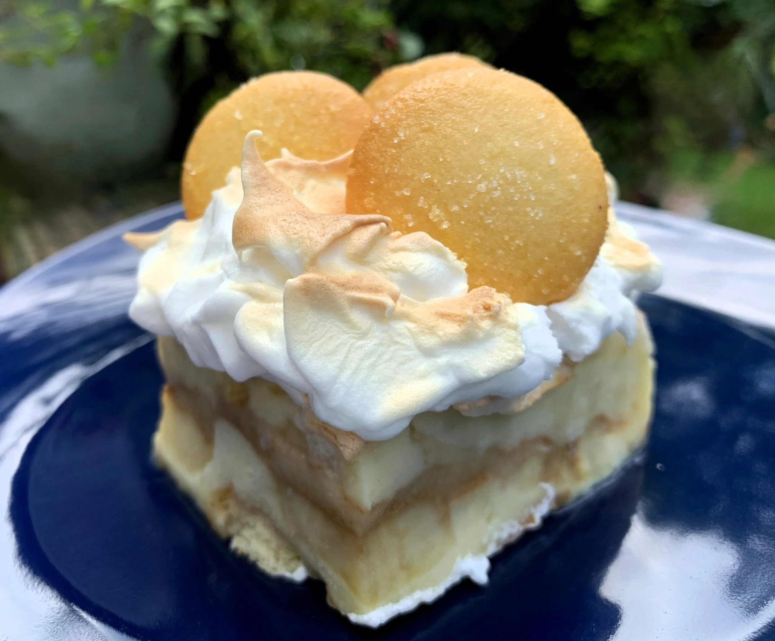 A glass baking dish filled with Southern banana pudding layered with bananas and vanilla wafers, topped with toasted meringue on a bright kitchen counter