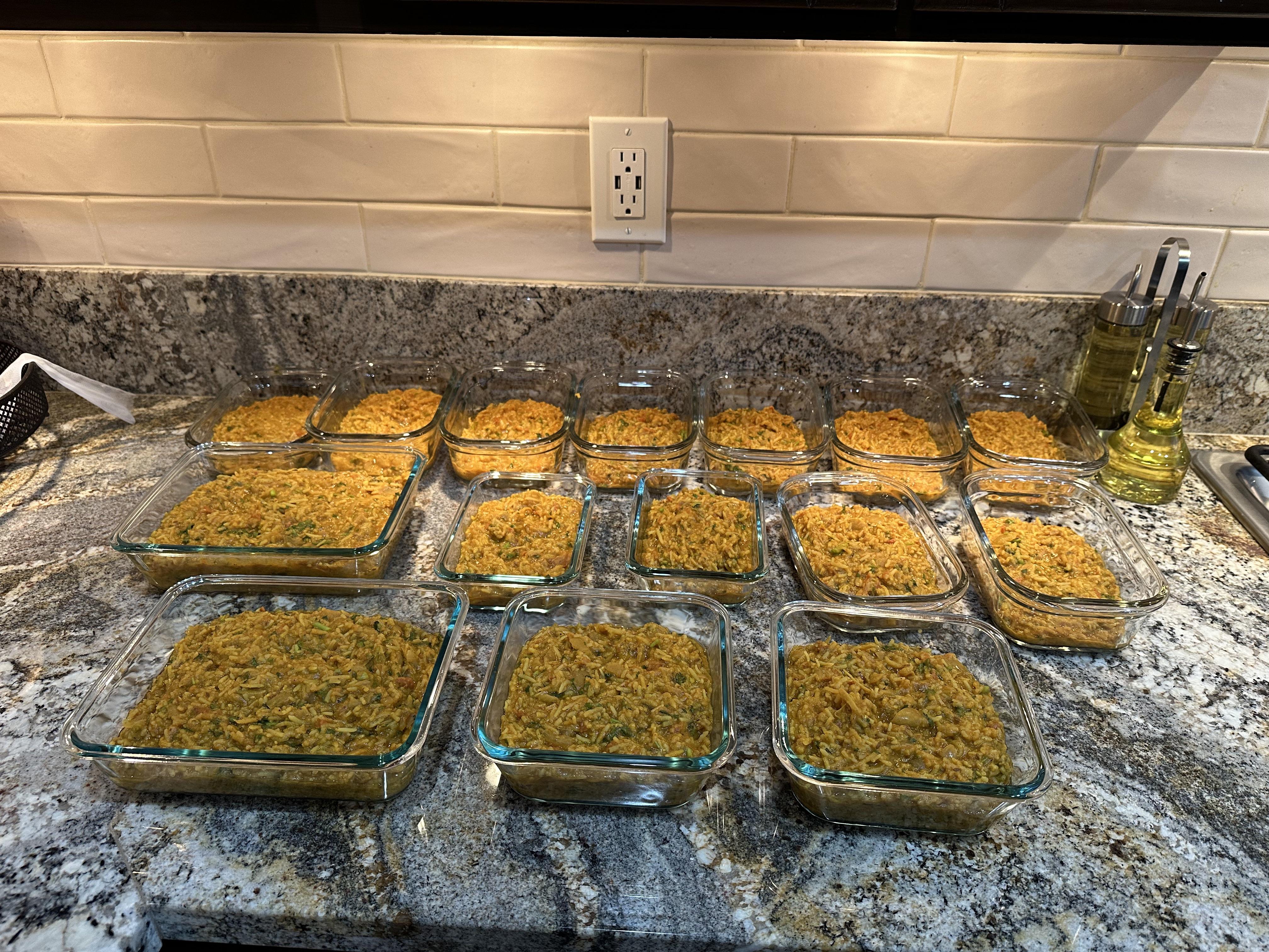 A glass meal prep container filled with leftover khichdi, covered with a lid, sitting on a refrigerator shelf