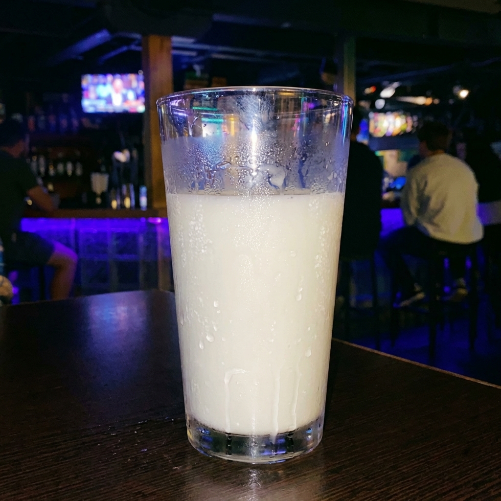 A glass of cold milk with condensation on the outside