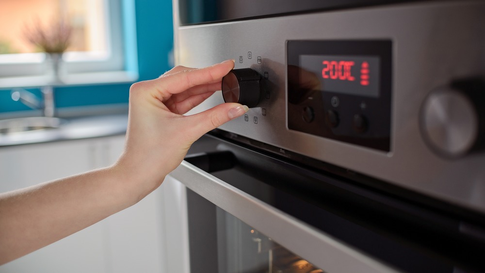 A home oven preheating with the rack set in the upper third, warm kitchen light