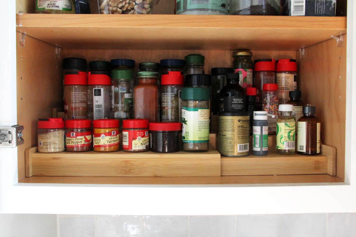 A labeled glass spice jar of Creole seasoning sitting on a pantry shelf next to other spices