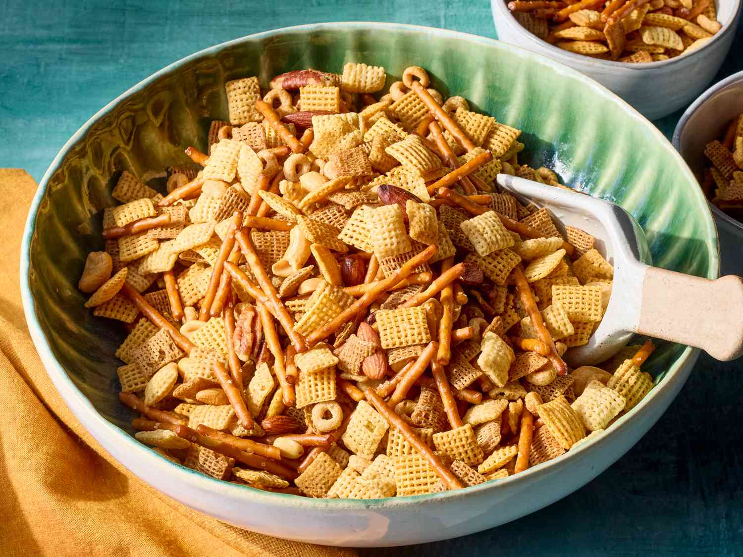 A large bowl filled with Chex cereal, pretzels, mixed nuts, and bagel chips