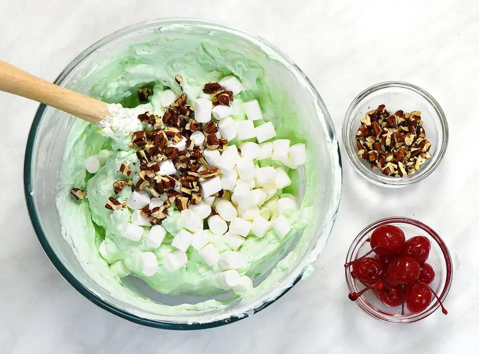 A large mixing bowl on a kitchen counter with a rubber spatula beside it, ready for making pistachio salad