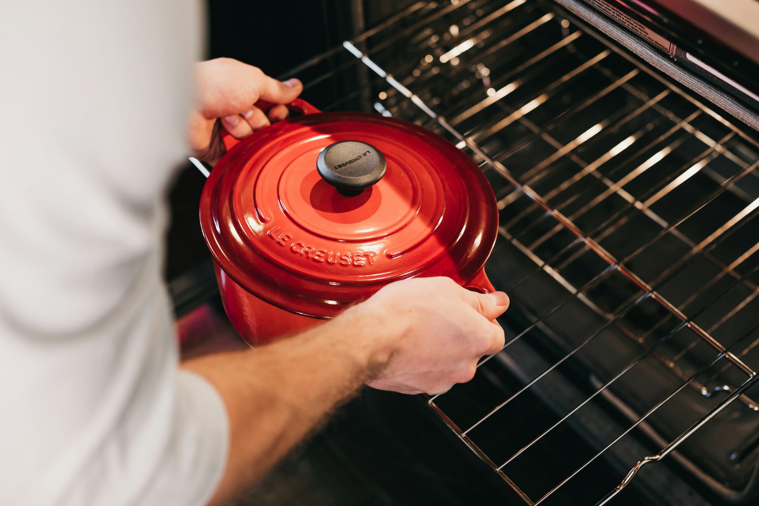 A lidded cast iron Dutch oven preheating on the middle oven rack