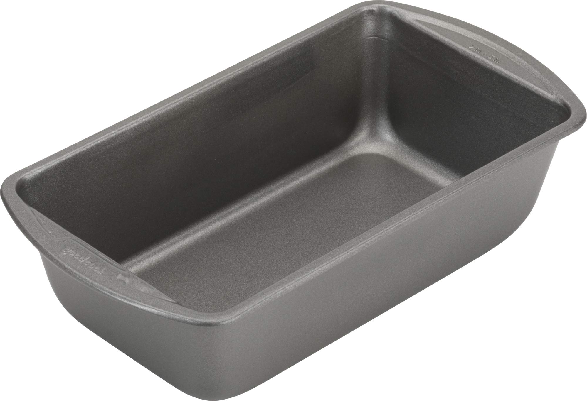 A metal 9x5-inch loaf pan on a kitchen counter next to parchment paper and a mixing bowl