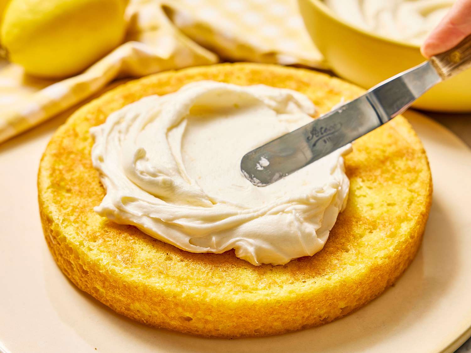 A neat lineup of cream cheese, butter, powdered sugar, vanilla extract, and a pinch of salt on a light-colored kitchen counter, ready to be mixed