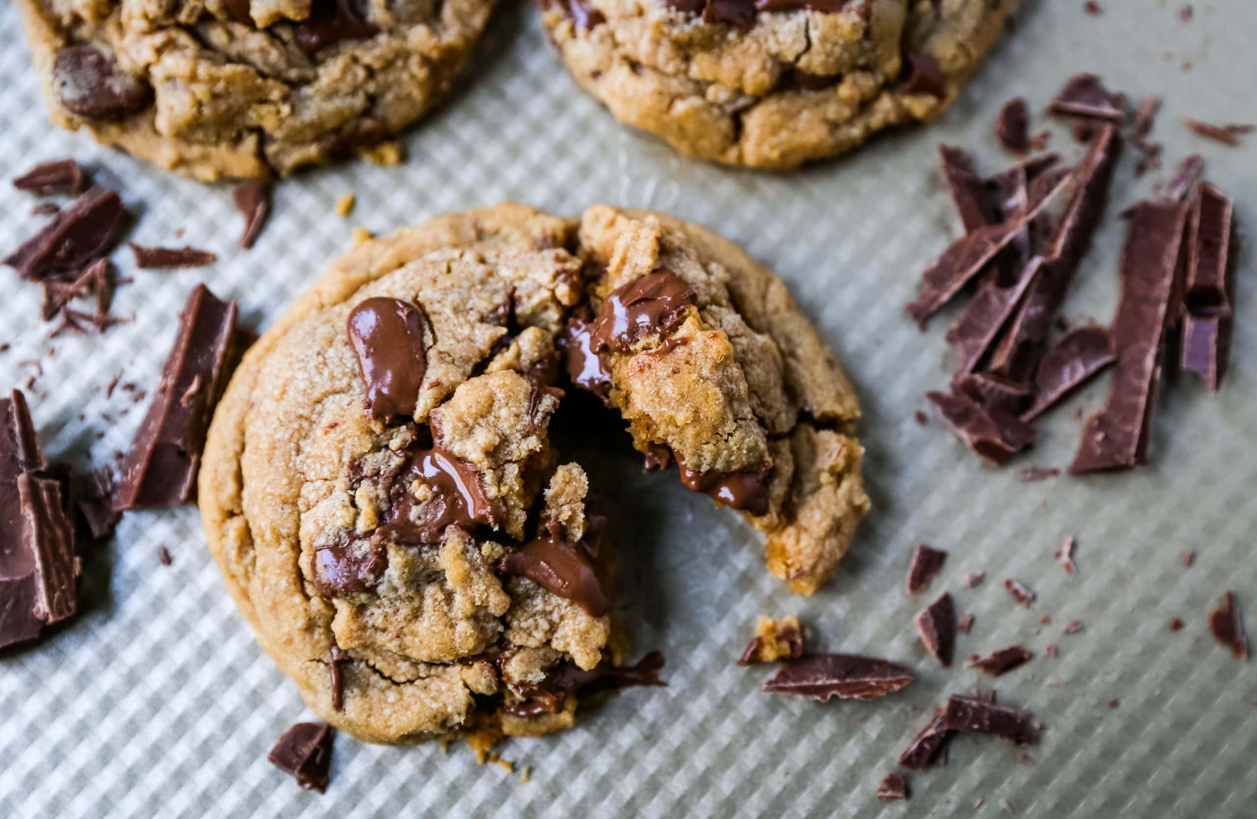 A peanut butter chocolate chip cookie broken open to show a chewy center with melted chocolate chips