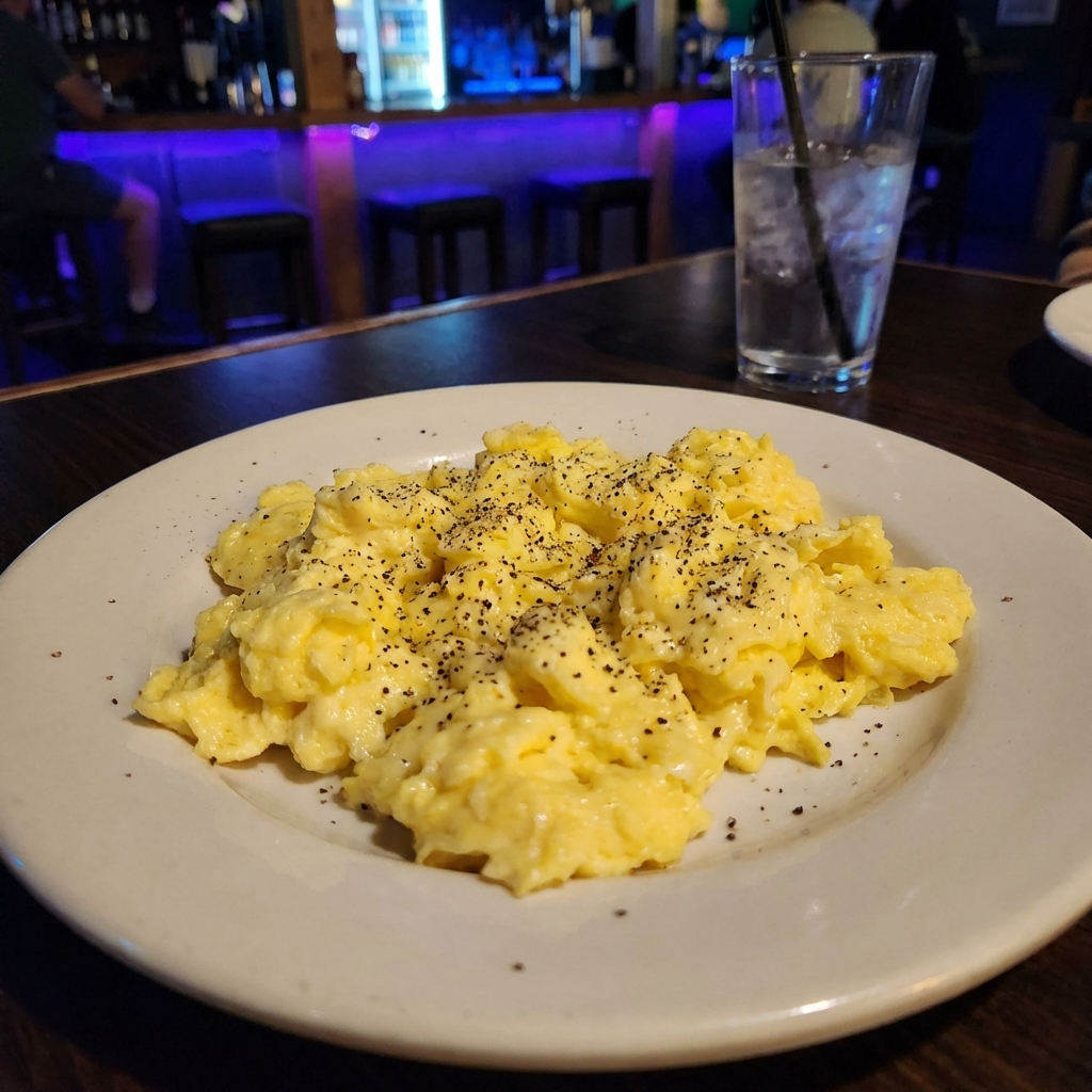 A plate of scrambled eggs with black pepper