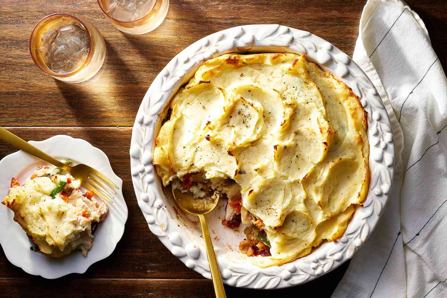 A portion of leftover shepherd’s pie in a clear airtight container, showing layers of savory meat filling and mashed potato topping