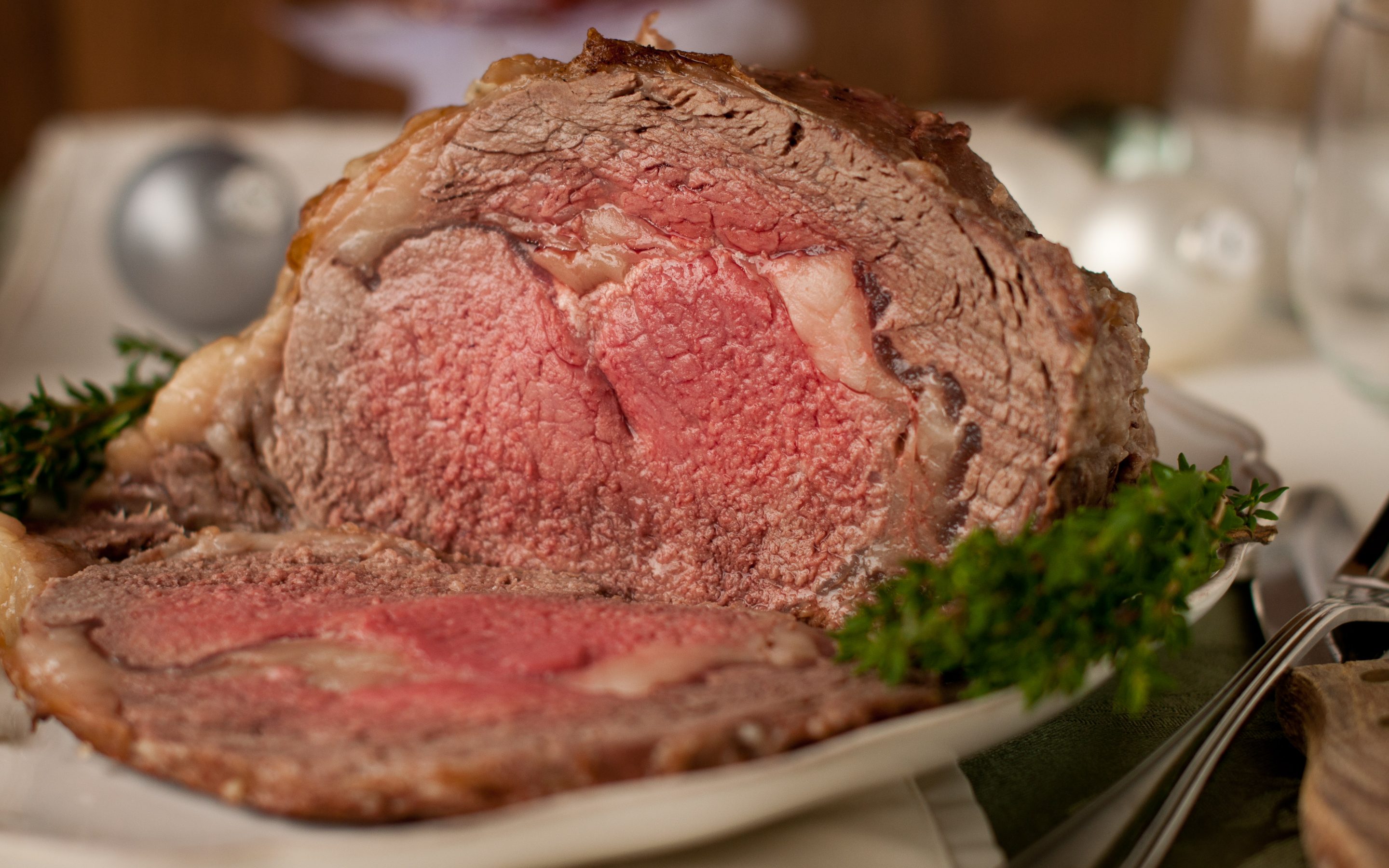 A raw boneless prime rib roast on a rack in a roasting pan, evenly salted on all sides in a home kitchen