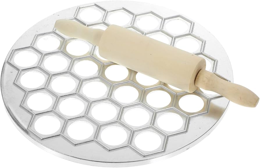 A rolling pin, round cutter, and small bowl of flour on a clean kitchen counter set up for shaping dumplings