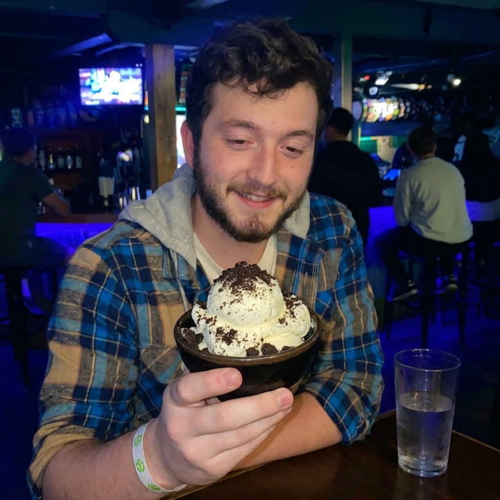 A scoop of vanilla ice cream in a small bowl with cookie crumbs