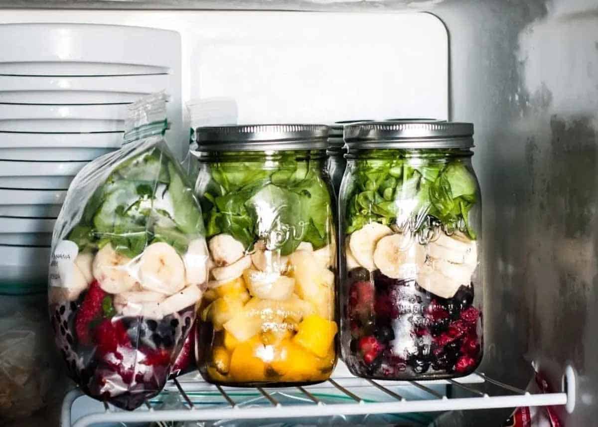 A sealed mason jar filled with peanut butter banana smoothie sitting on a refrigerator shelf with condensation on the glass