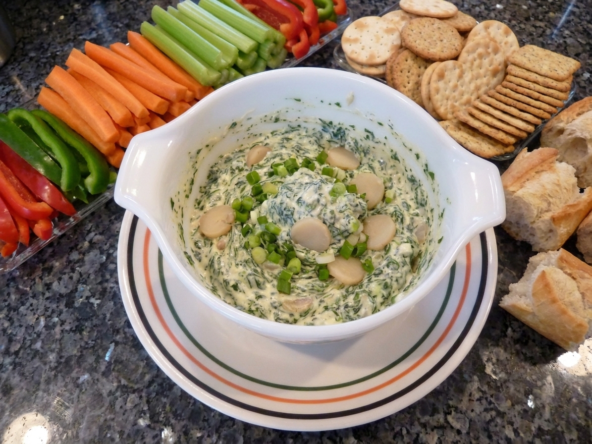 A serving bowl of Knorr vegetable dip on a table surrounded by carrots, celery, bell pepper strips, crackers, and torn bread