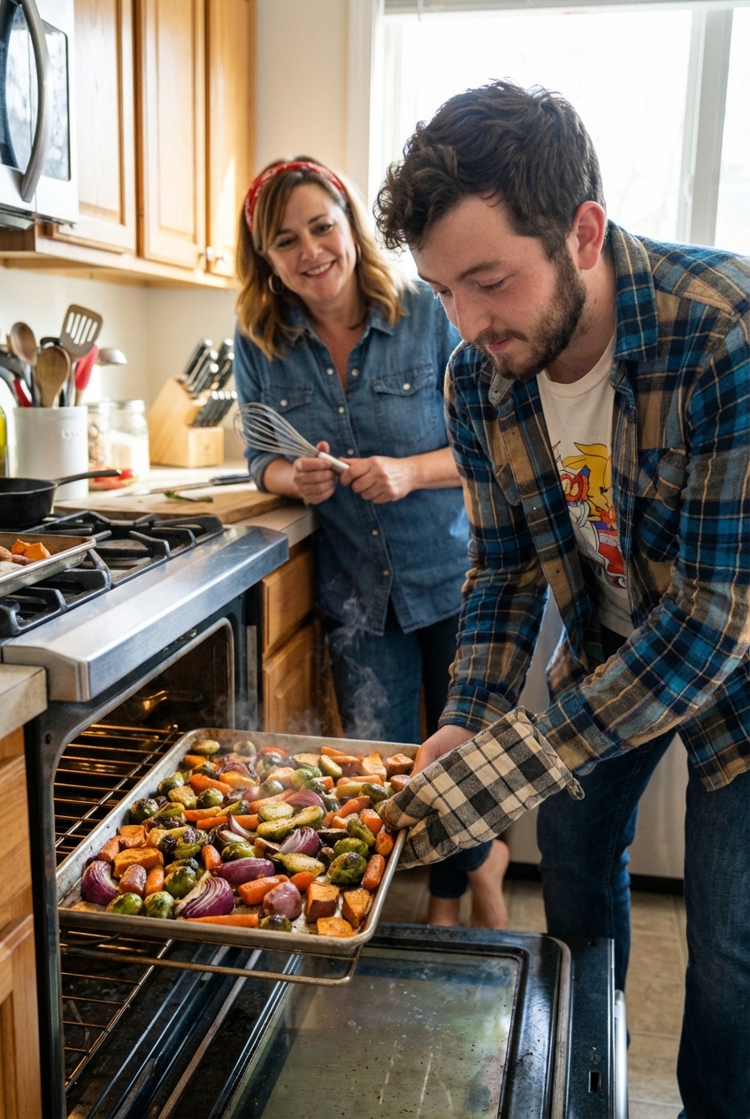 A sheet pan being pulled from the oven with roasted vegetables browned and caramelized