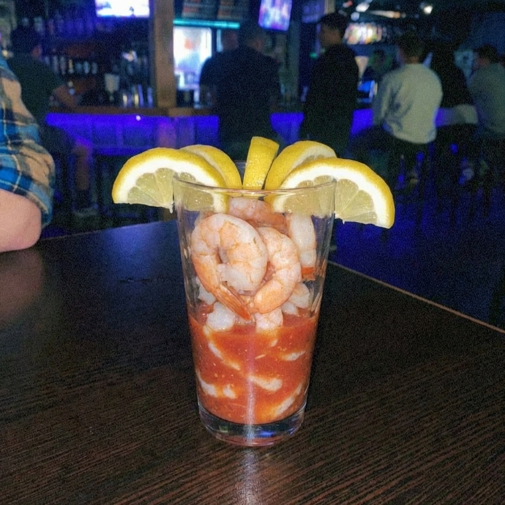 A shrimp cocktail glass with lemon wedges