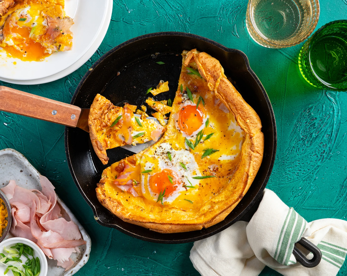 A sliced Dutch baby pancake showing a crisp browned edge and a soft custardy center