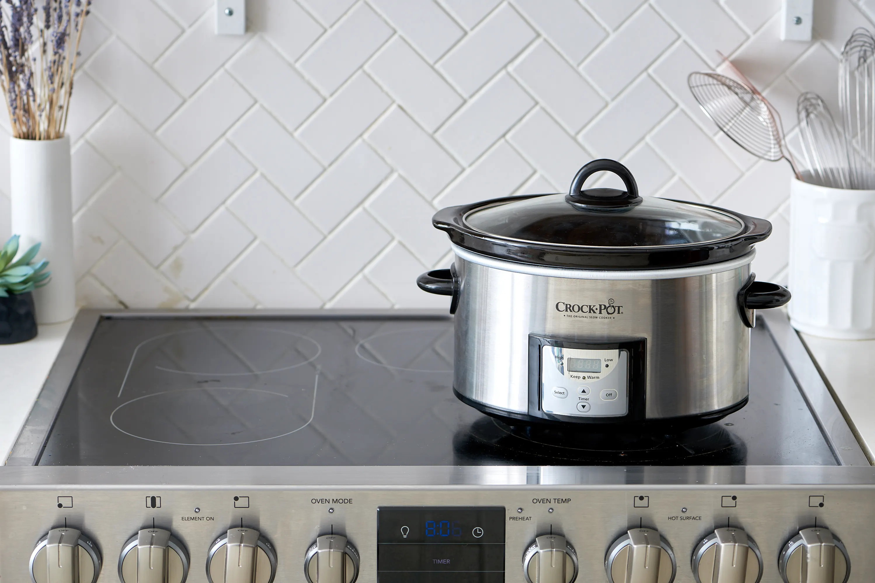 A slow cooker sitting on a clean kitchen counter with the lid beside it, ready for cooking