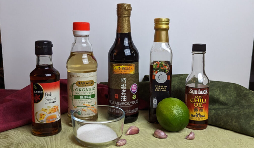A small bowl of soy sauce, rice vinegar, honey, sesame oil, and chili crisp being whisked together on a kitchen counter