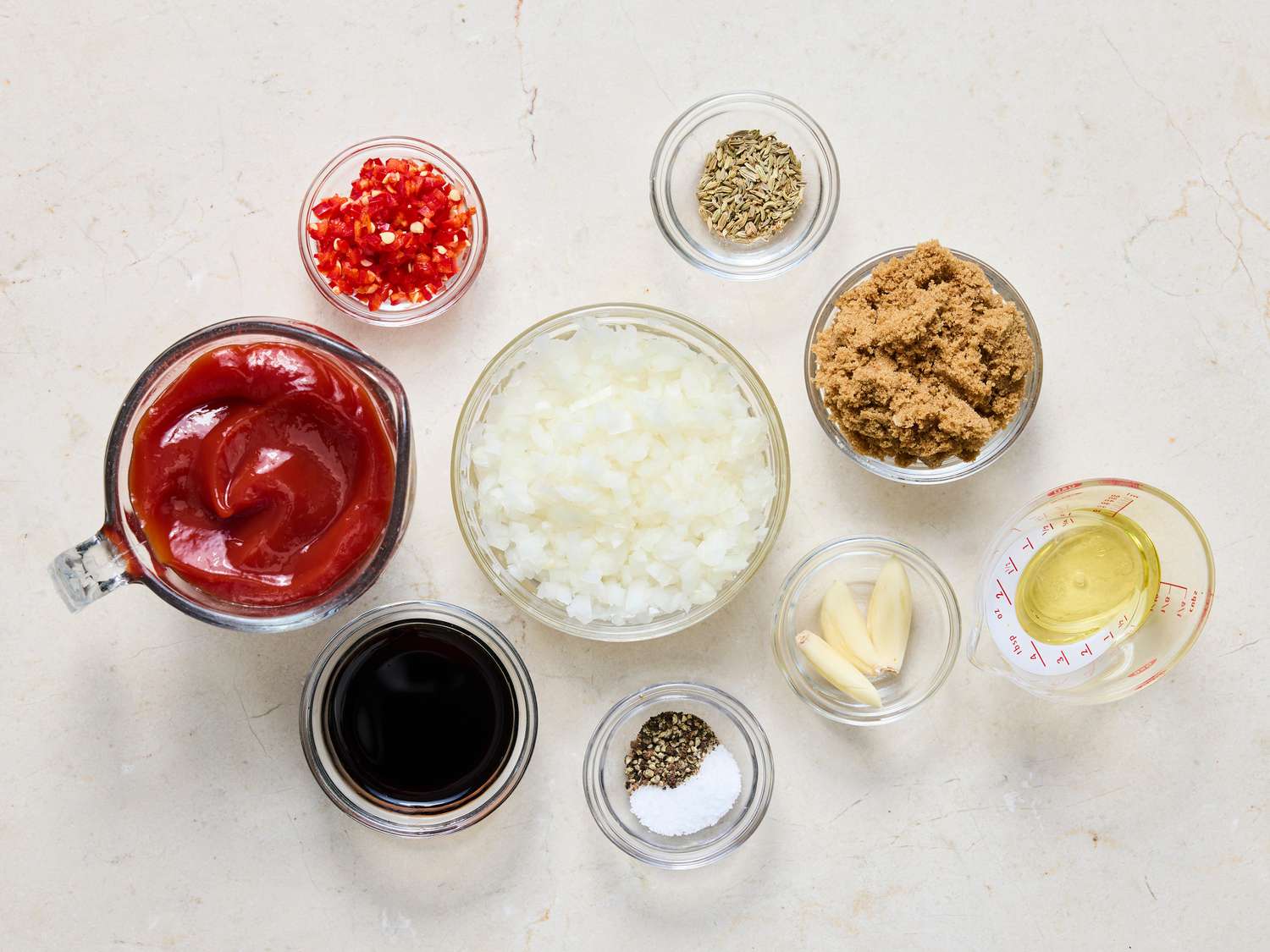 A small bowl with ketchup, brown sugar, vinegar, Worcestershire, mustard, and spices ready to be whisked into a quick barbecue sauce on a kitchen counter