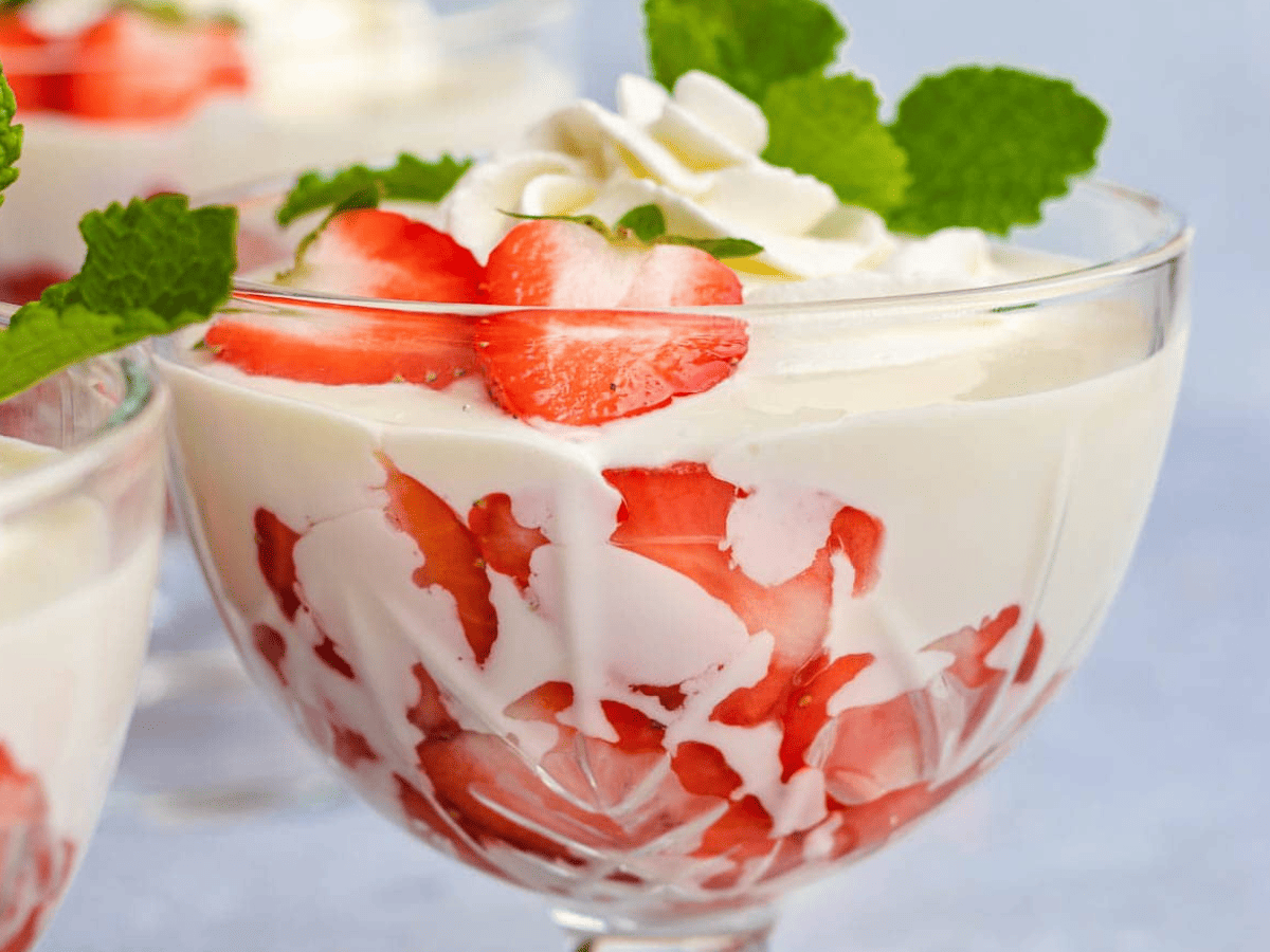A small group of ingredients on a kitchen counter including sweetened condensed milk, vanilla extract, a cut lime, and a small bowl of salt