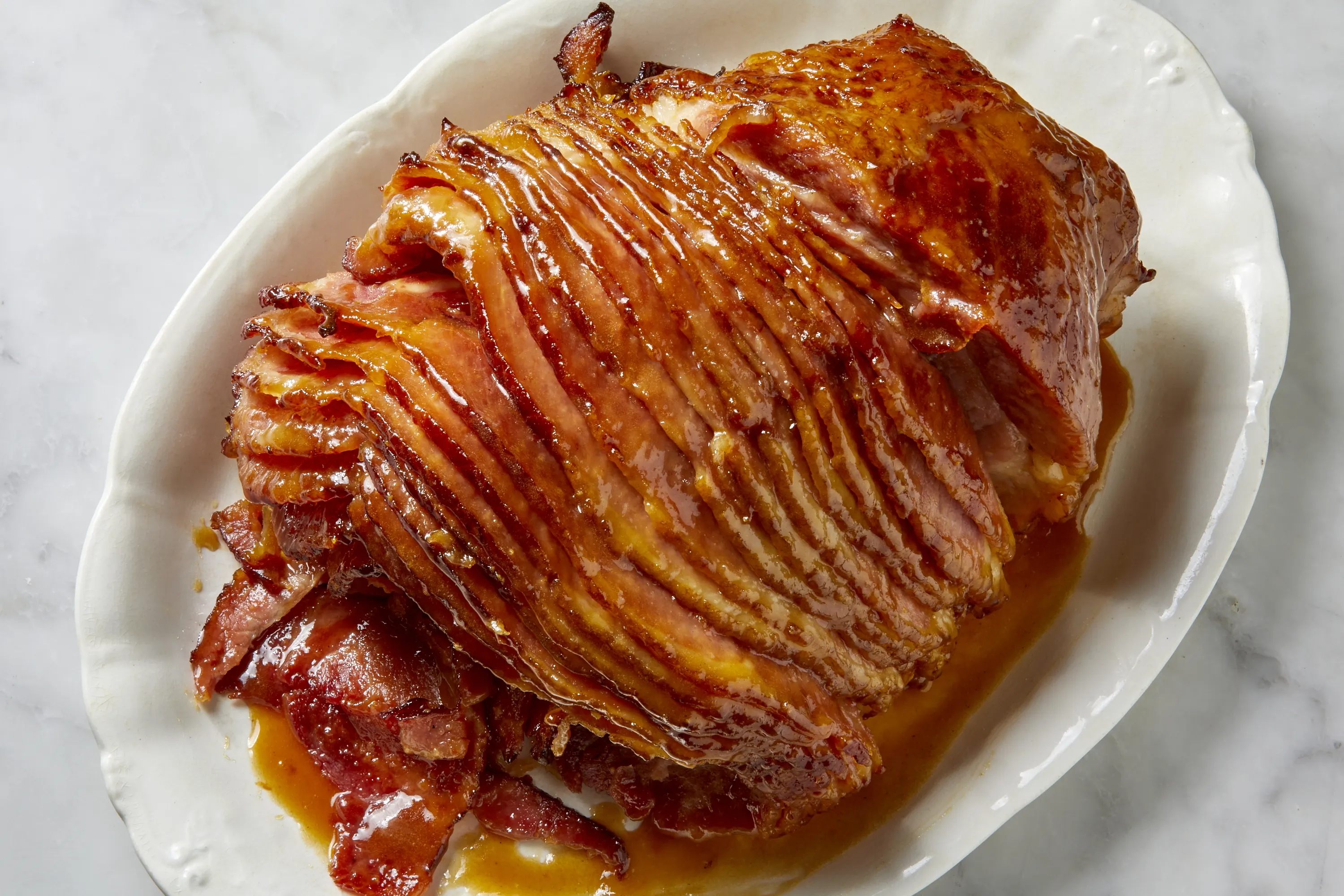 A small saucepan on a stove with honey and sugars being whisked together into a glossy glaze