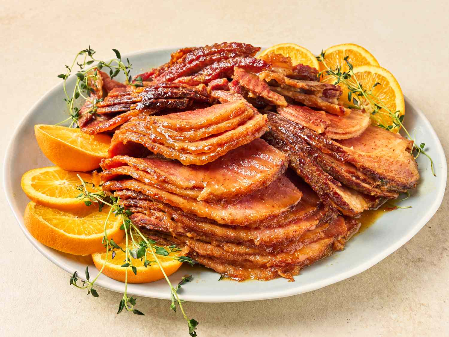 A spiral sliced ham sitting in a slow cooker coated in glossy honey mustard brown sugar glaze in a warm-lit kitchen