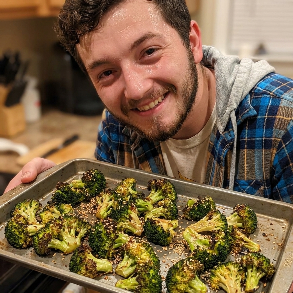 A tray of roasted broccoli with charred edges and sesame seeds