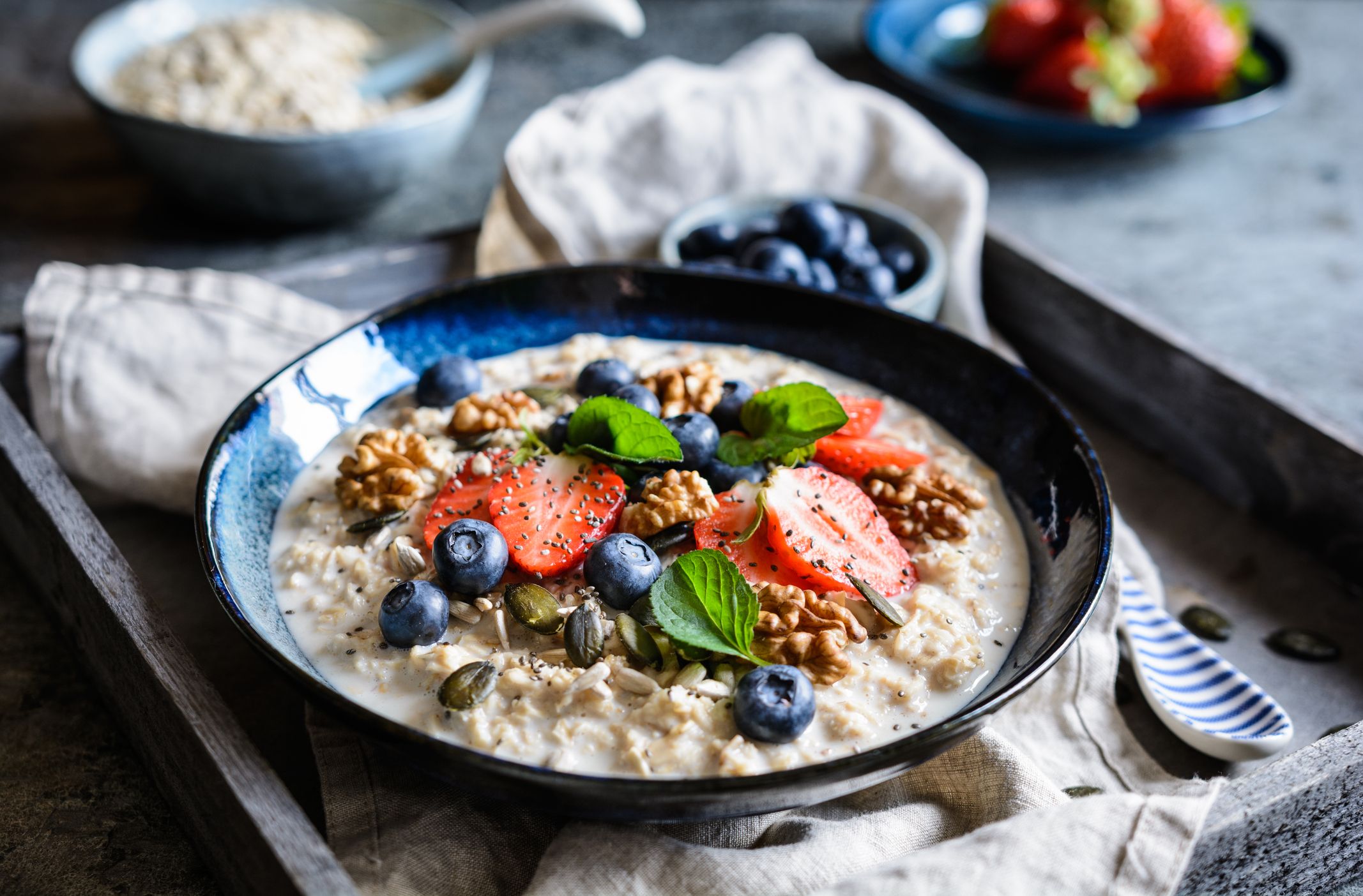 A warm bowl of creamy Irish oats topped with sliced banana, toasted nuts, and a drizzle of honey on a light kitchen table