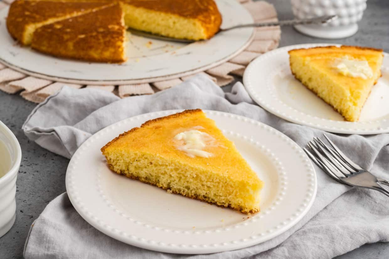 A warm slice of sweet cornbread on a plate with melting butter