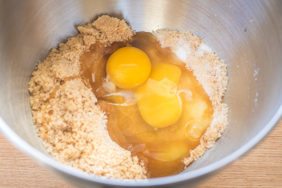 Applesauce, cinnamon, flour, eggs, and brown sugar arranged on a clean kitchen counter, ready for baking