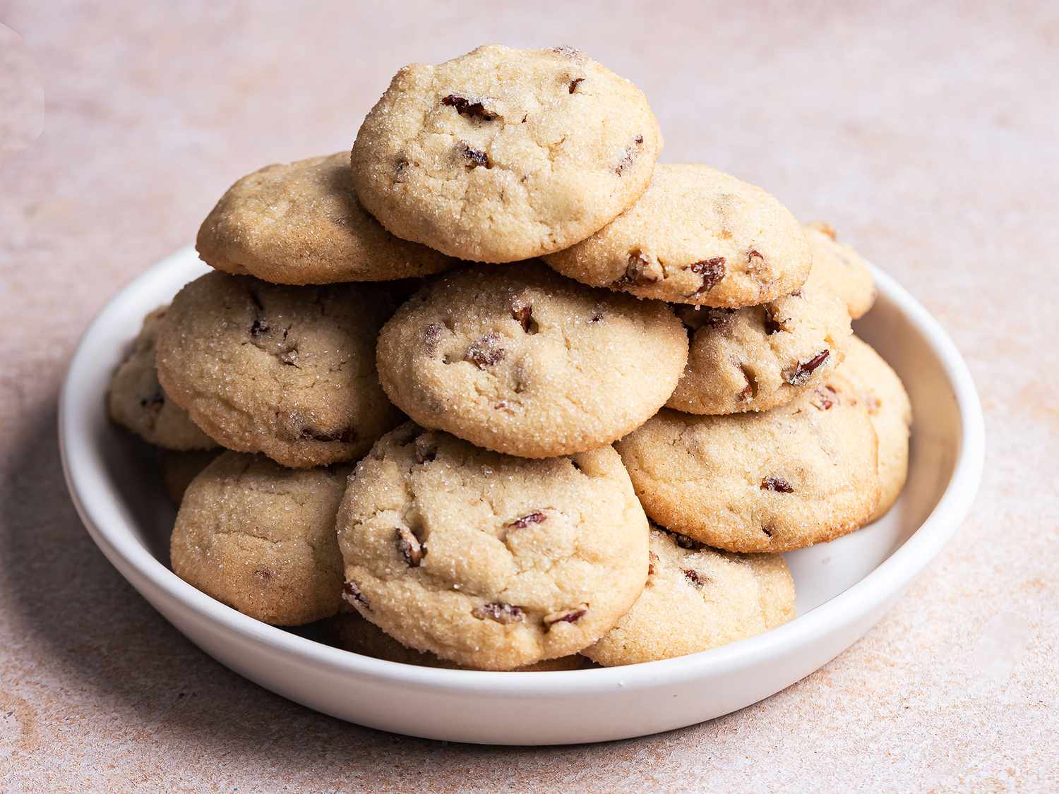 Bowls of flour, powdered sugar, toasted pecans, butter, vanilla, and salt arranged on a bright kitchen counter