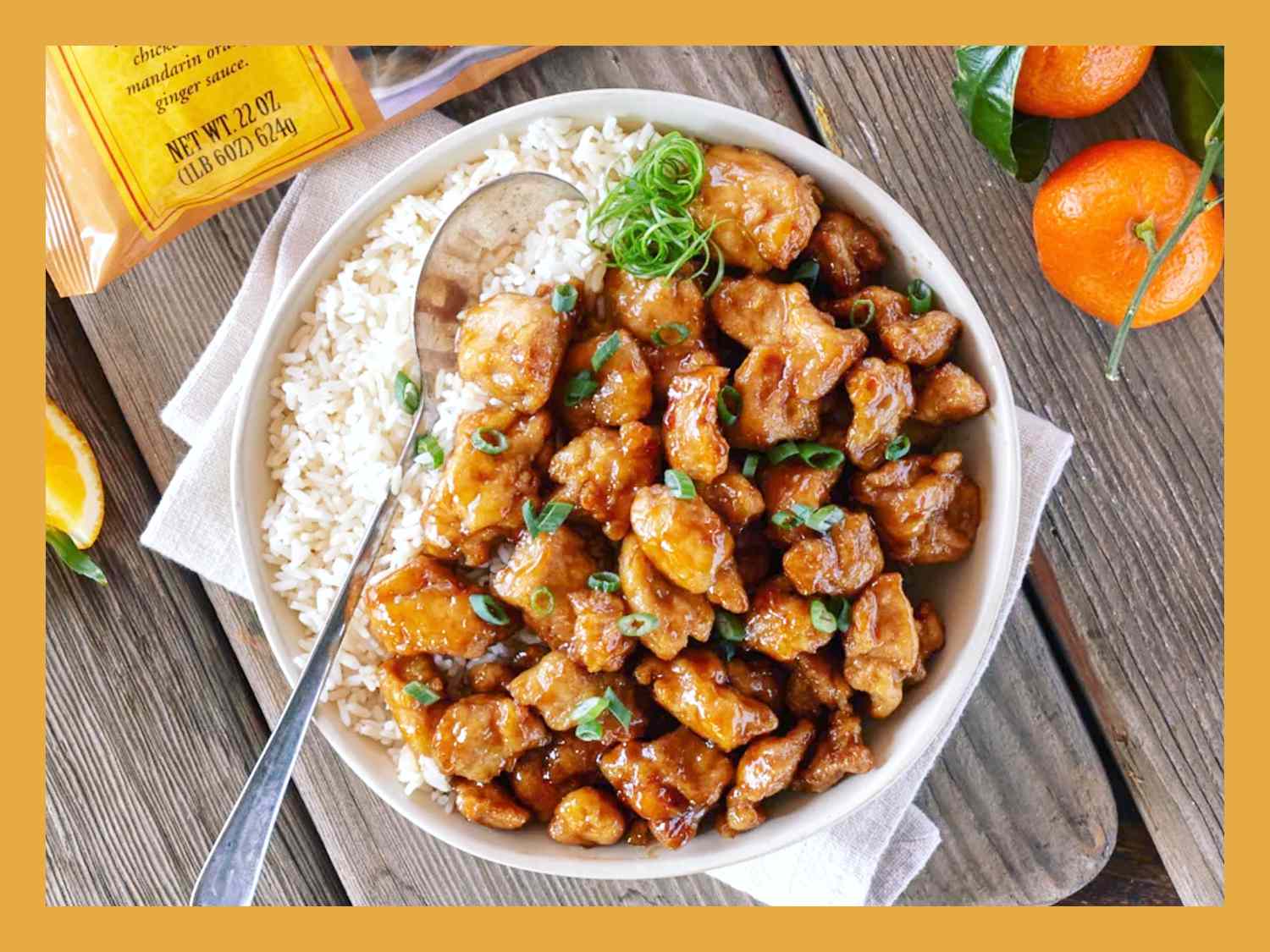 Breaded orange chicken pieces baking on a sheet pan in a home oven, turning golden brown with crisp edges