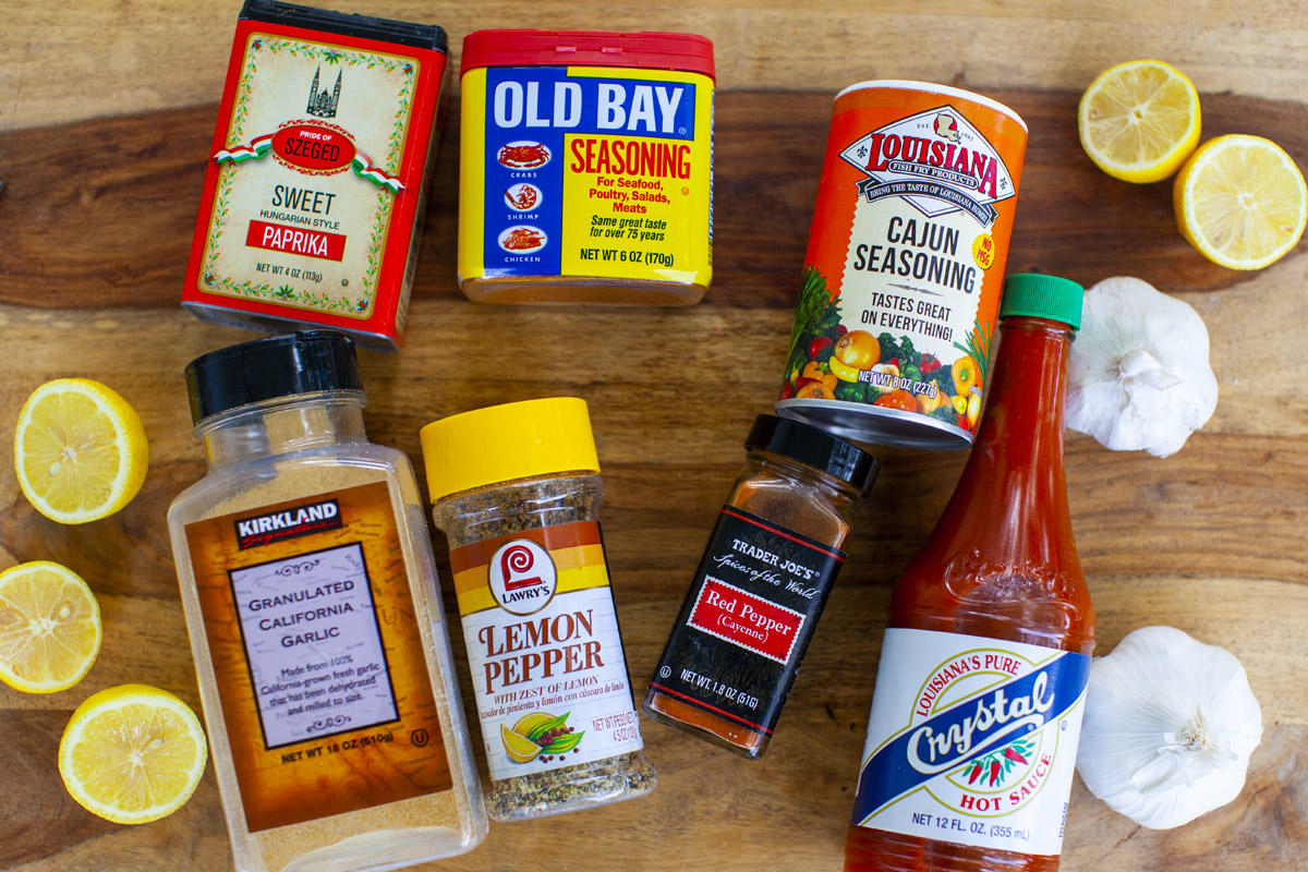 Butter, garlic, lemon, Cajun seasoning, paprika, and hot sauce arranged on a bright kitchen counter ready to make seafood boil sauce
