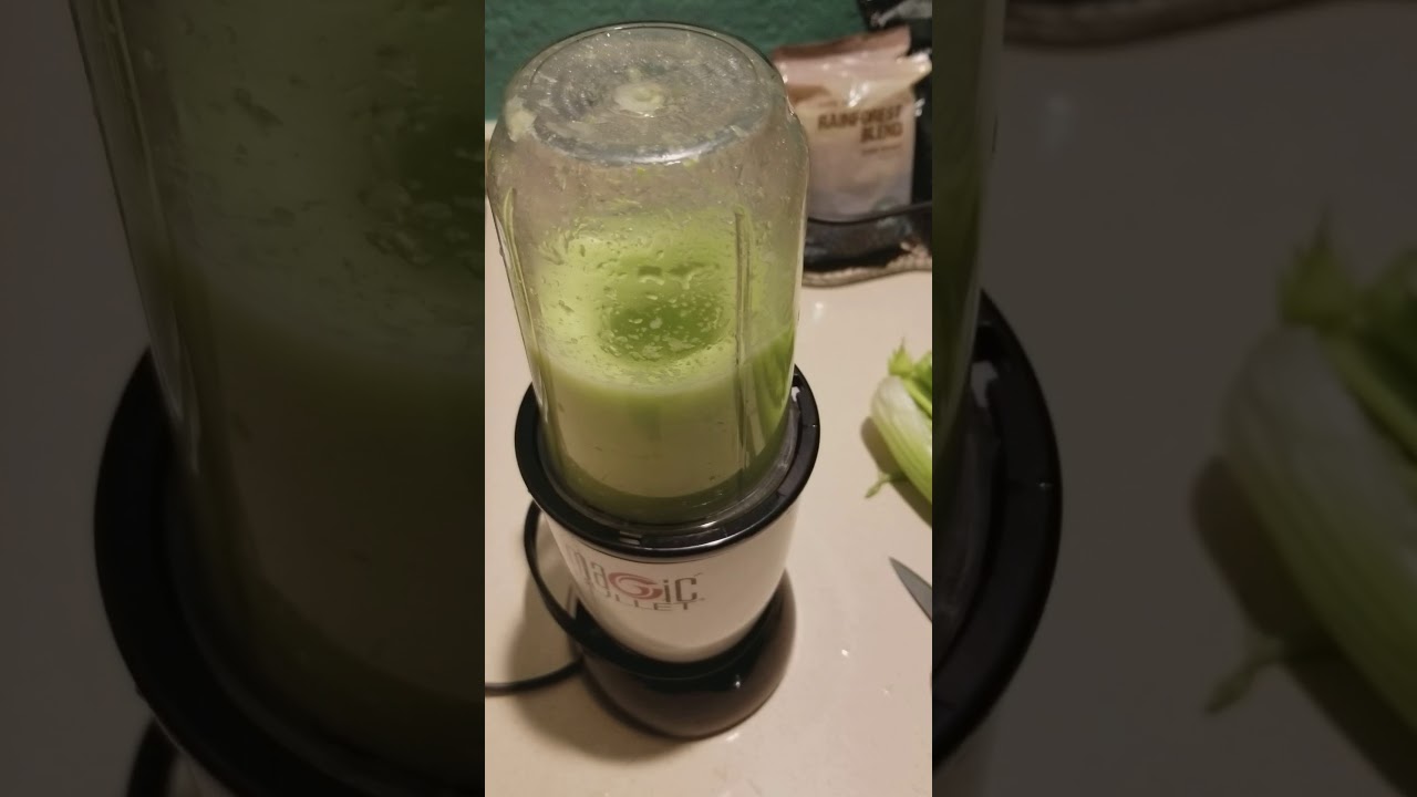 Celery pieces being blended into a vivid green mixture in a high-speed blender on a kitchen counter
