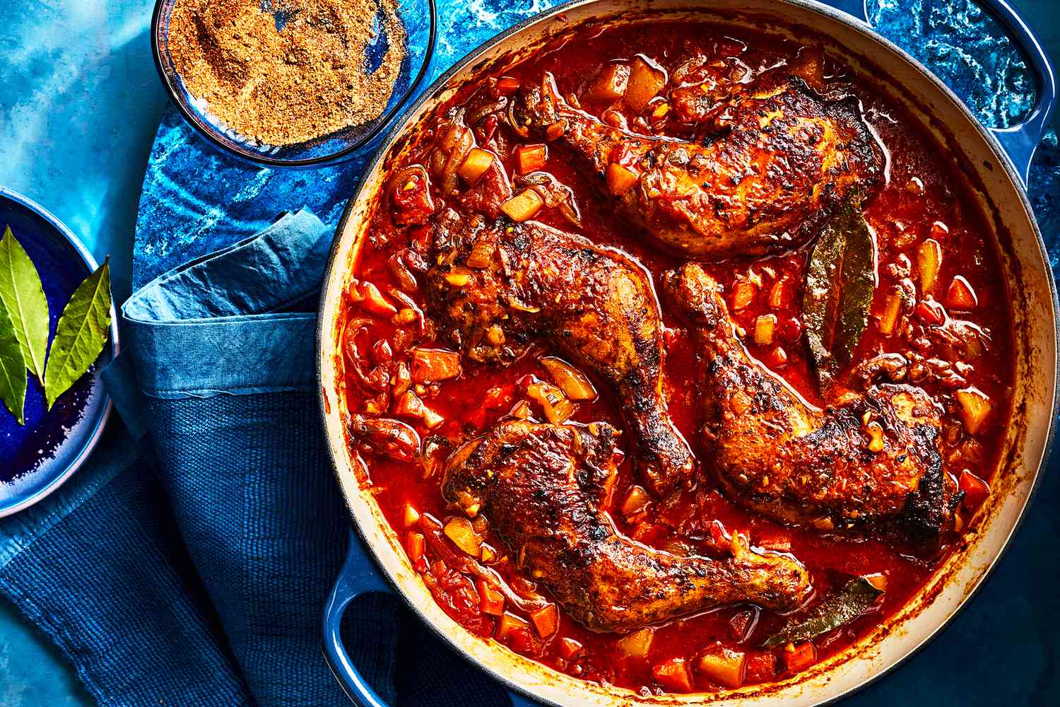 Chicken pieces browning in a Dutch oven on a stovetop with golden edges and bits forming on the bottom of the pot