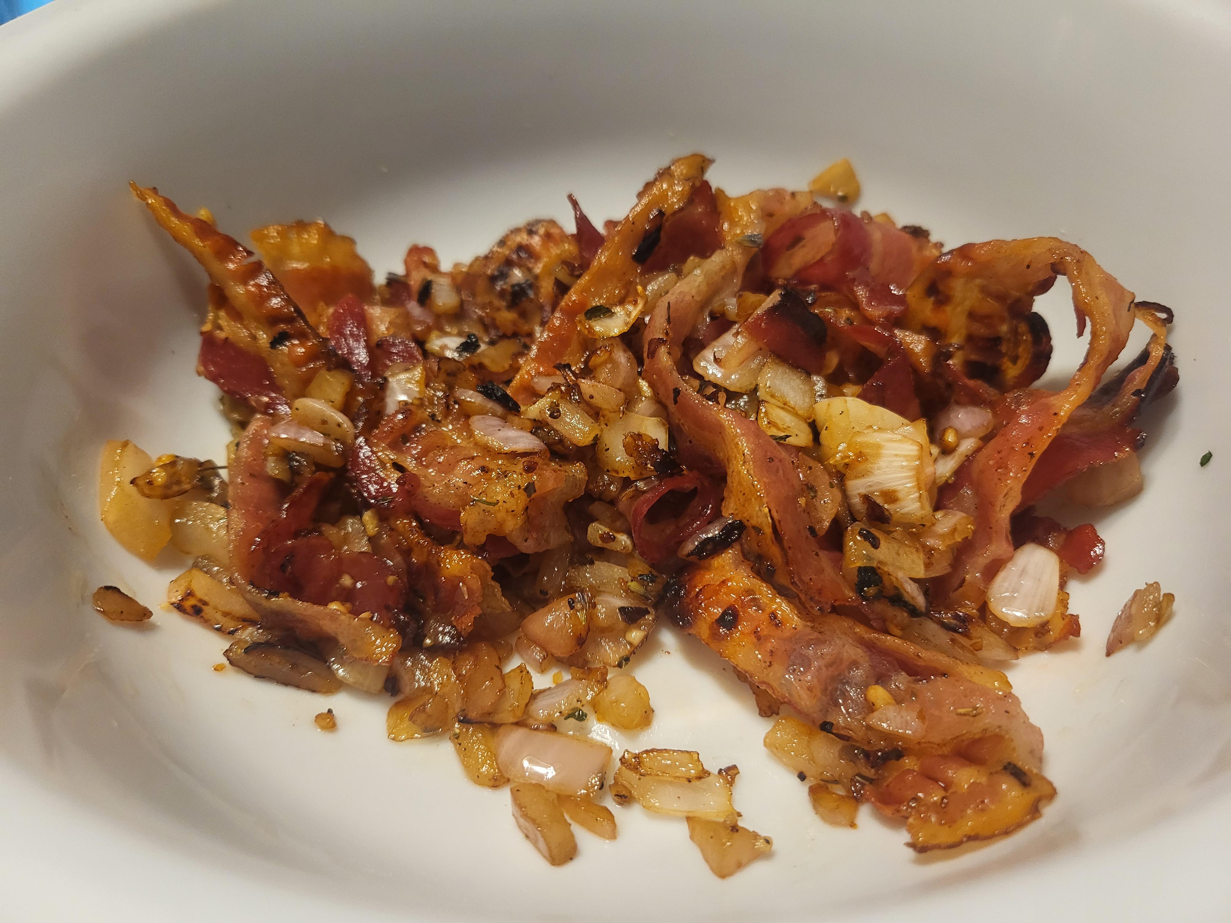 Chopped bacon, diced onion, minced garlic, and canned beans arranged in small bowls on a kitchen counter